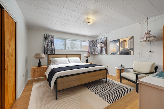 bedroom featuring light hardwood / wood-style flooring and ornamental molding