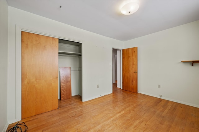 unfurnished bedroom featuring light hardwood / wood-style floors and a closet