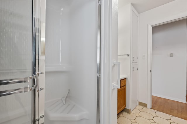 bathroom with vanity and a shower with door