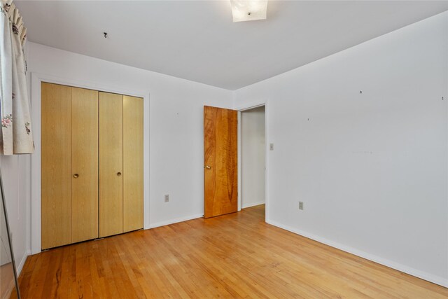 unfurnished bedroom featuring a closet and light hardwood / wood-style flooring