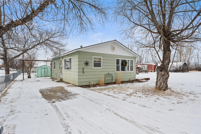 view of front of property with a storage shed