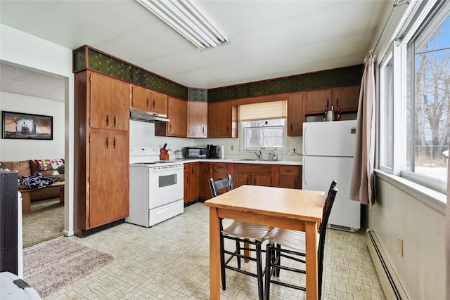 kitchen with baseboard heating, white appliances, and sink