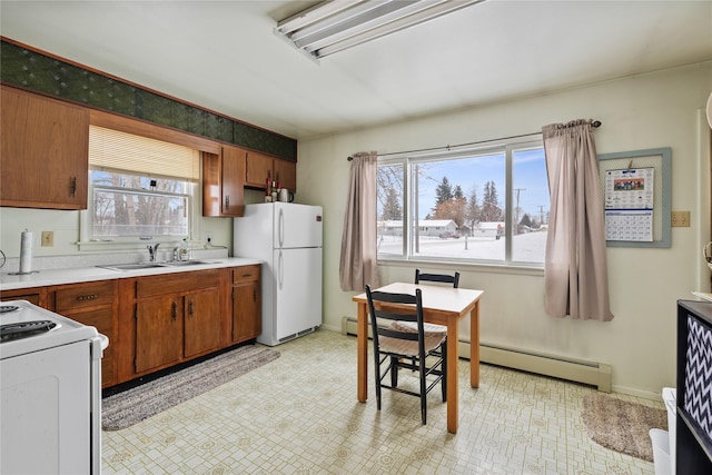 kitchen featuring white appliances, sink, and a baseboard heating unit