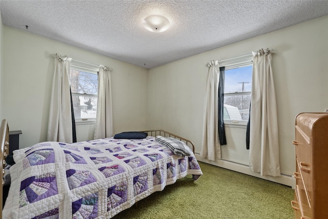 bedroom with a textured ceiling, carpet floors, multiple windows, and a baseboard heating unit