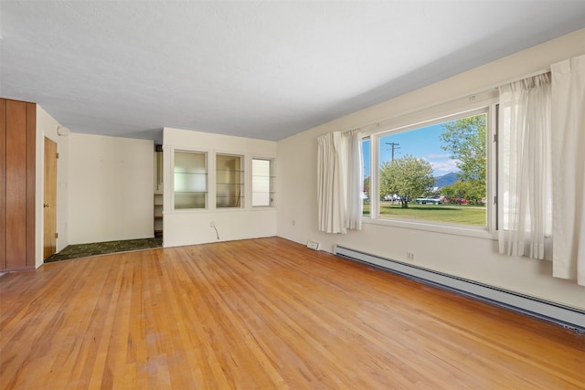 119 Fair St, Deer Lodge, MT 59722 - unfurnished living room with a baseboard radiator and light wood-type flooring