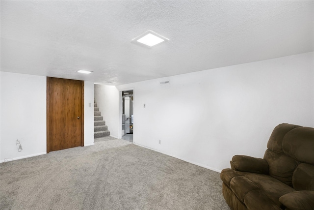 living area featuring light carpet and a textured ceiling