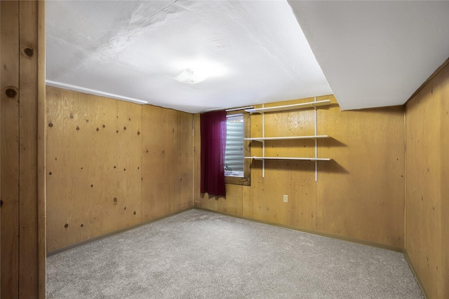 spare room with light carpet and wooden walls