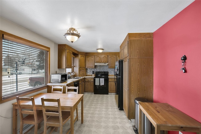 kitchen with sink, decorative backsplash, and black appliances