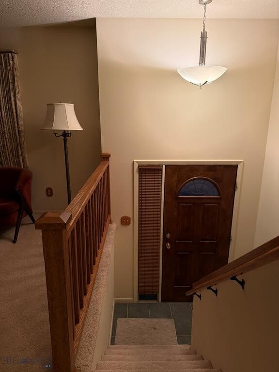 3435 Parkway St, Butte, MT 59701 - entryway with carpet, a textured ceiling, and stairs