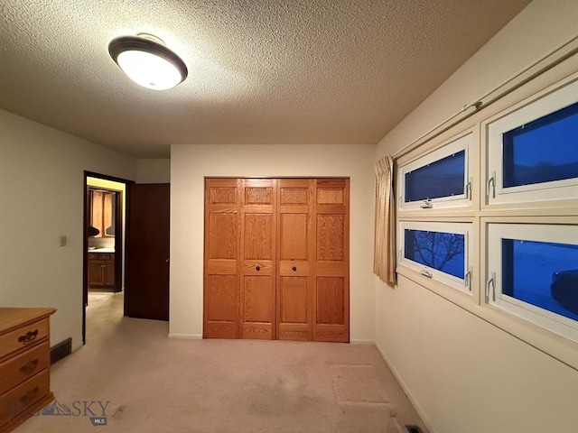 3435 Parkway St, Butte, MT 59701 - unfurnished bedroom with a closet, a textured ceiling, baseboards, and light carpet