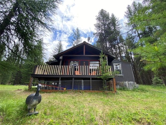 view of front of property featuring a wooden deck and a front lawn