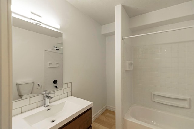 full bathroom featuring hardwood / wood-style flooring,  shower combination, backsplash, vanity, and toilet