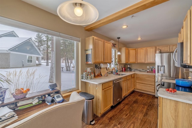 kitchen featuring dark wood-style flooring, pendant lighting, appliances with stainless steel finishes, a sink, and light countertops