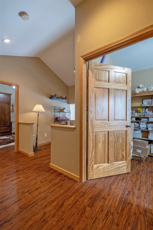 interior space with wood finished floors, baseboards, and lofted ceiling