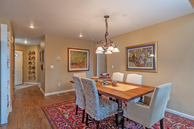 dining space with dark wood-type flooring, recessed lighting, baseboards, and a chandelier