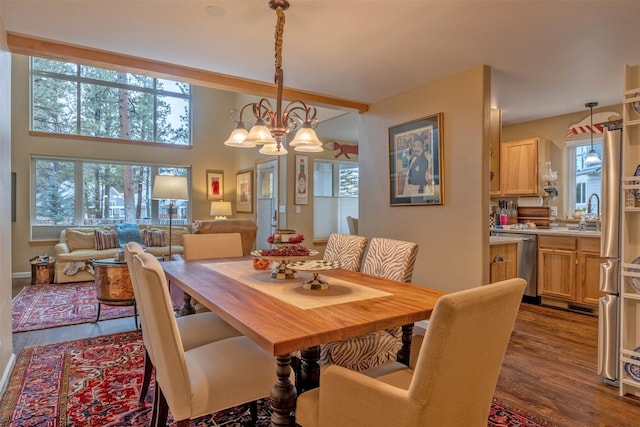 dining room featuring an inviting chandelier, dark wood-style flooring, and a wealth of natural light