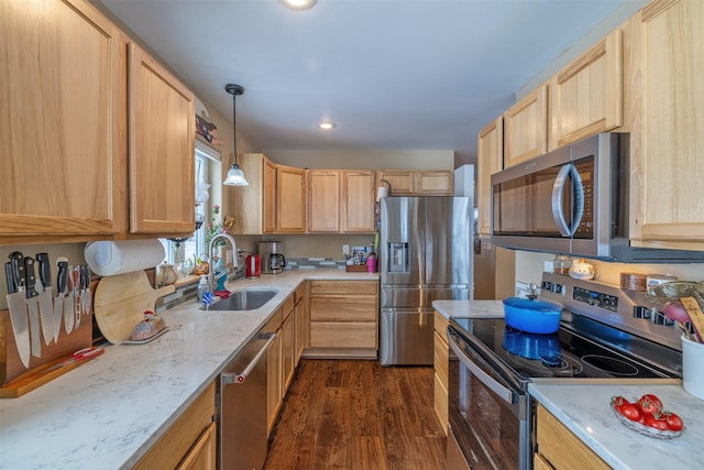 kitchen featuring pendant lighting, dark wood-style flooring, light brown cabinets, a sink, and stainless steel appliances