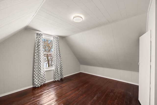 additional living space with vaulted ceiling and dark hardwood / wood-style floors