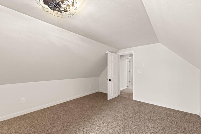 bonus room with vaulted ceiling, carpet floors, and a textured ceiling