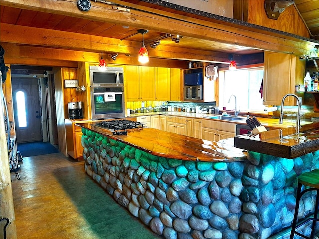 kitchen with sink, kitchen peninsula, stainless steel appliances, wooden ceiling, and beam ceiling