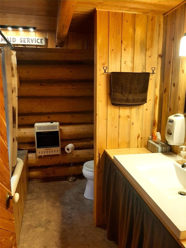 bathroom with toilet, rustic walls, heating unit, wood walls, and a tub