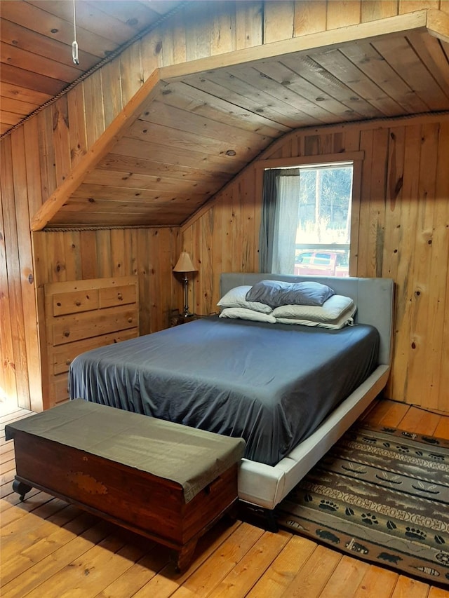 bedroom featuring lofted ceiling, wood ceiling, light hardwood / wood-style flooring, and wood walls