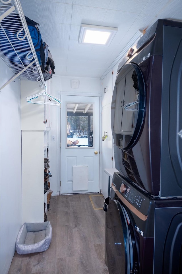 clothes washing area with stacked washer / dryer and hardwood / wood-style floors