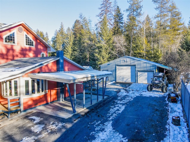 exterior space with a garage, an outdoor structure, and a carport