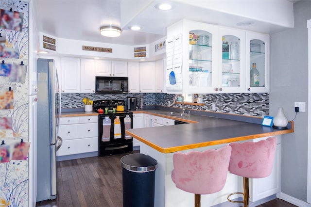 kitchen featuring white cabinets, kitchen peninsula, sink, and black appliances