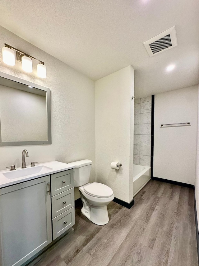 bathroom with vanity, hardwood / wood-style floors, a textured ceiling, and toilet