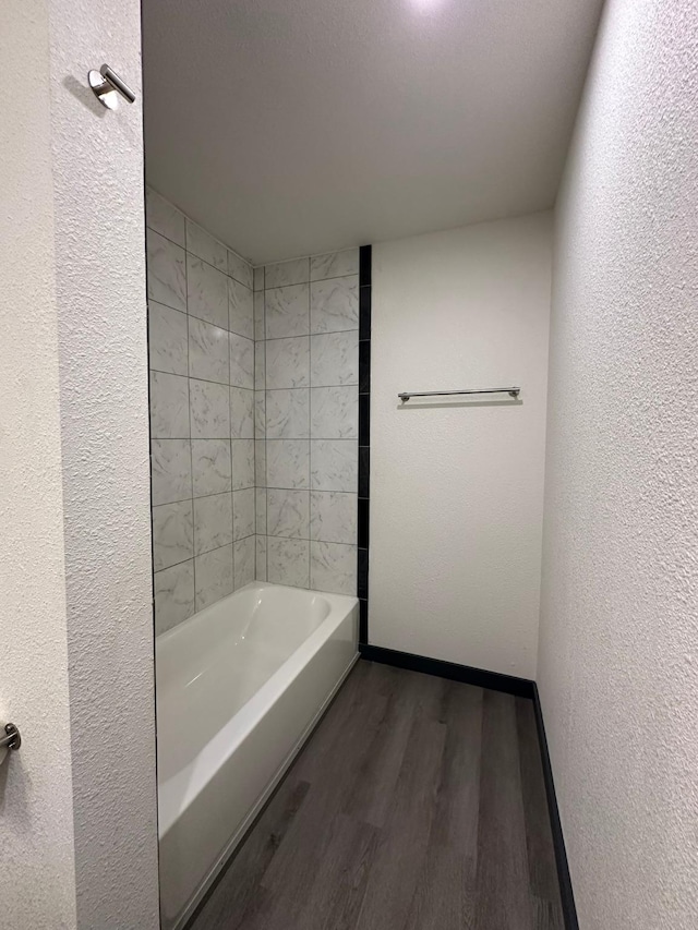 bathroom featuring tiled shower / bath and hardwood / wood-style floors