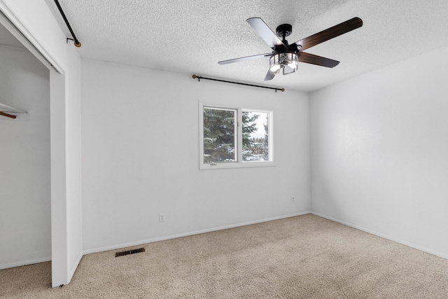 unfurnished bedroom with ceiling fan, a closet, carpet flooring, and a textured ceiling