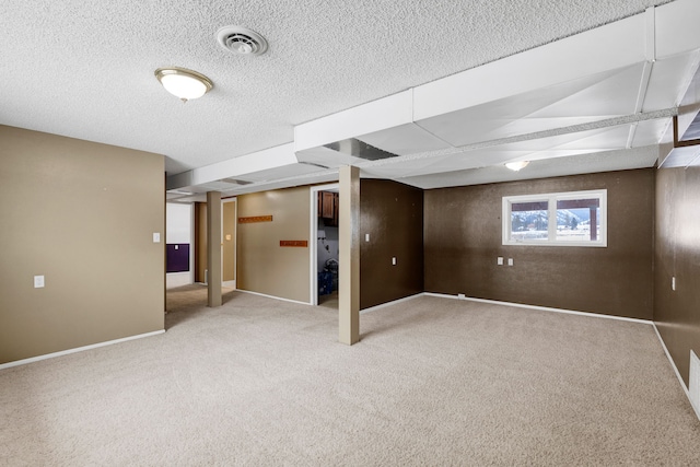 basement featuring carpet and a textured ceiling