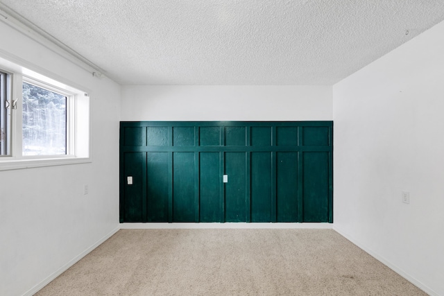 unfurnished bedroom featuring light colored carpet and a textured ceiling