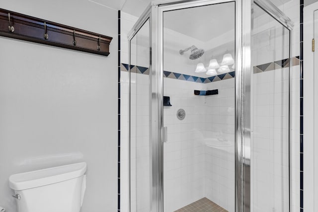 bathroom with toilet and a shower with shower door