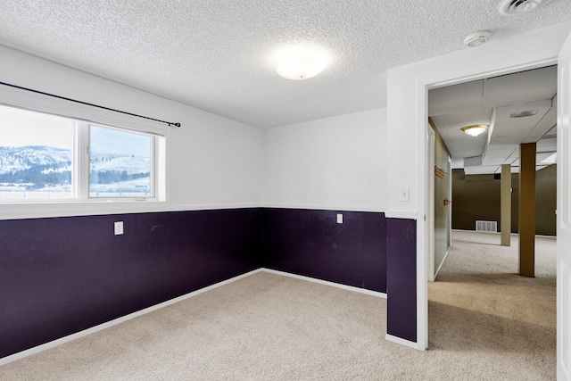 empty room featuring carpet and a textured ceiling