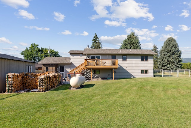 rear view of property with a deck and a lawn