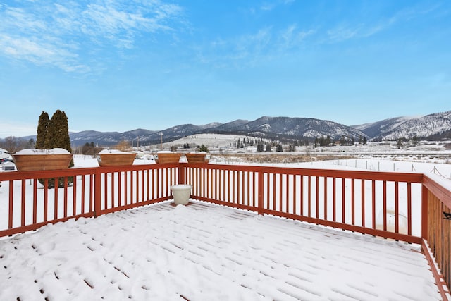 snow covered deck featuring a mountain view