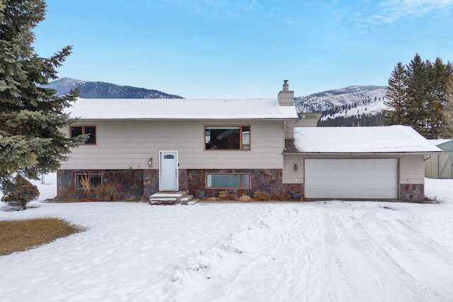 bi-level home featuring a garage and a mountain view