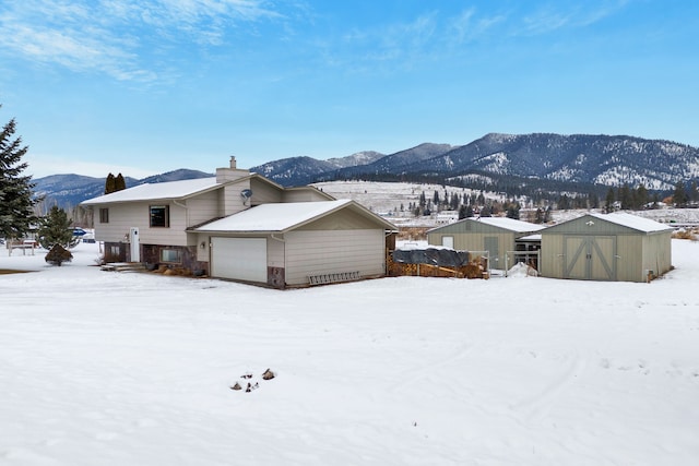 exterior space featuring a mountain view, a garage, and a storage shed