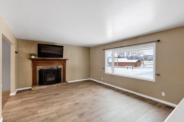 unfurnished living room with a fireplace and light hardwood / wood-style floors