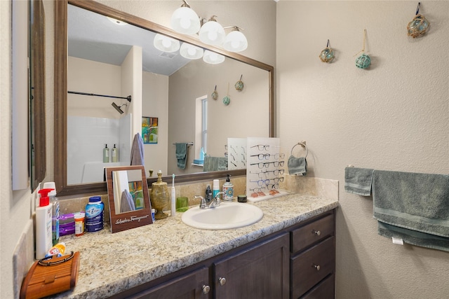 bathroom with walk in shower and vanity