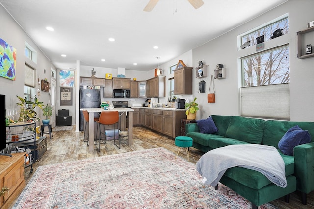 living room featuring ceiling fan and light hardwood / wood-style flooring