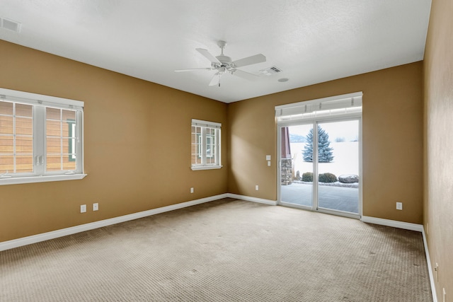 carpeted spare room featuring ceiling fan