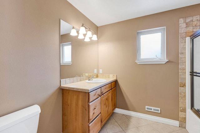 bathroom featuring vanity, tile patterned flooring, plenty of natural light, and toilet