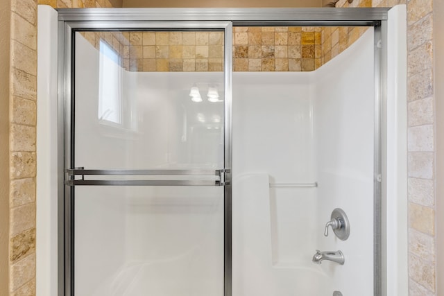 bathroom featuring bath / shower combo with glass door