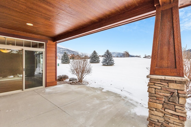 snow covered patio featuring a mountain view