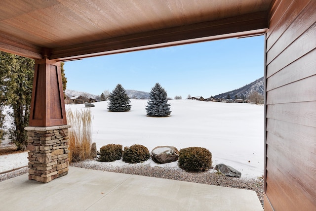 snow covered patio featuring a mountain view