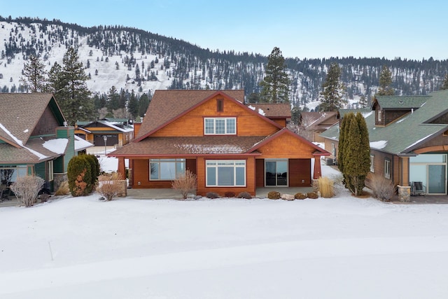 snow covered back of property featuring cooling unit and a mountain view