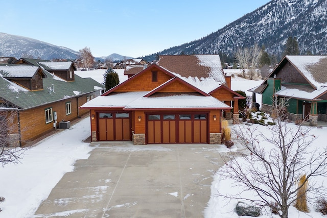 view of front of home featuring cooling unit, a mountain view, and a garage